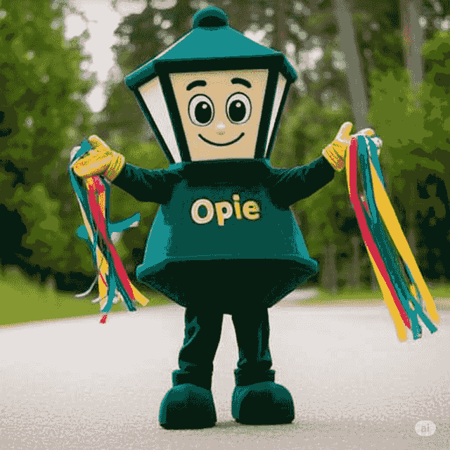 Opie the mascot waving with colorful streamers